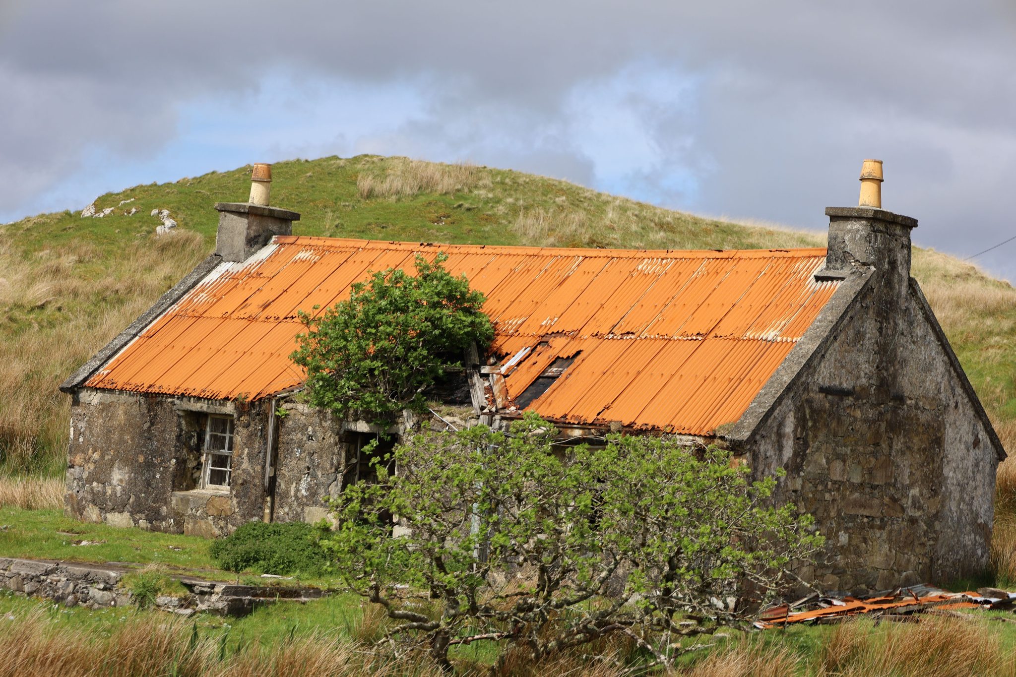 Derelict stone cottage with corrigated tin roof