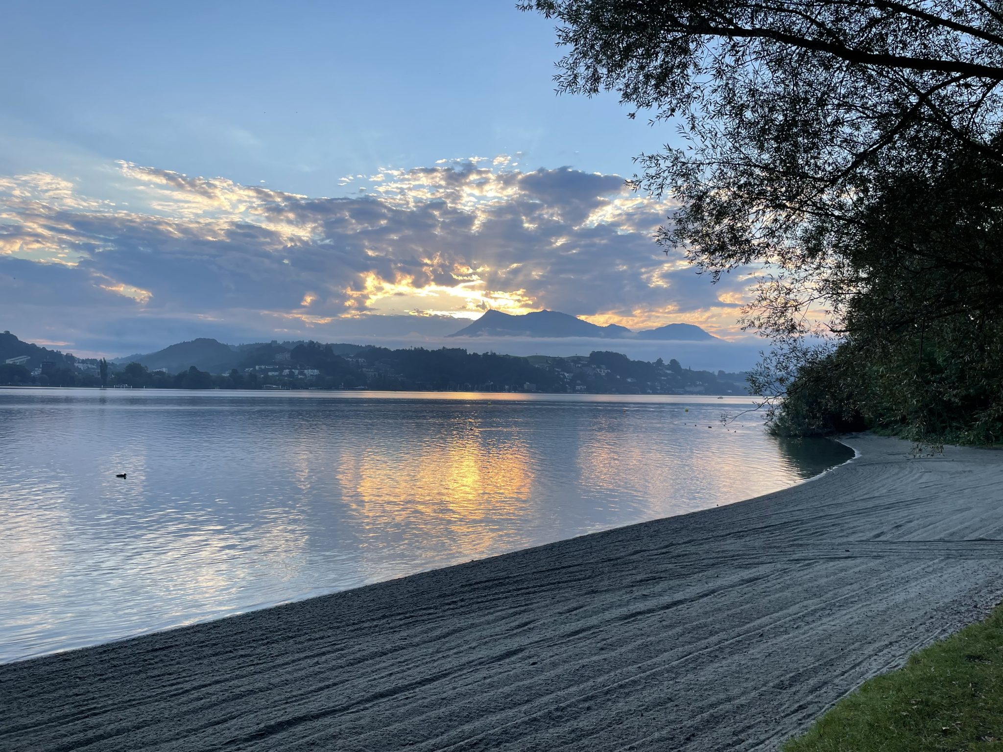 A sunrise seen from a beach in Lucerne, Switzerland. With the mountain "Rigi" in the background.