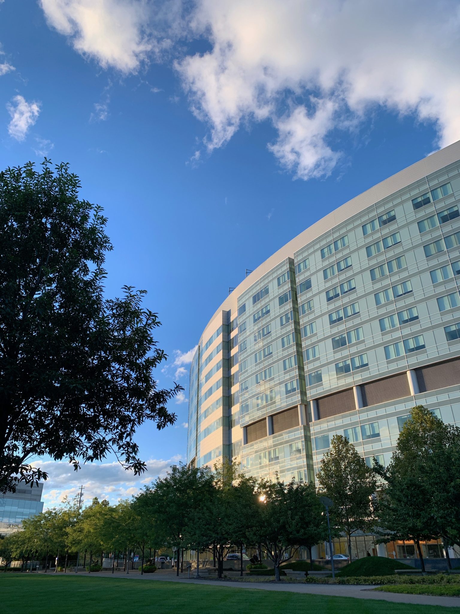 A tall, shiny building with a neatly manicured park with trees in the foreground. Nationwide Children's Hospital, Columbus, Ohio