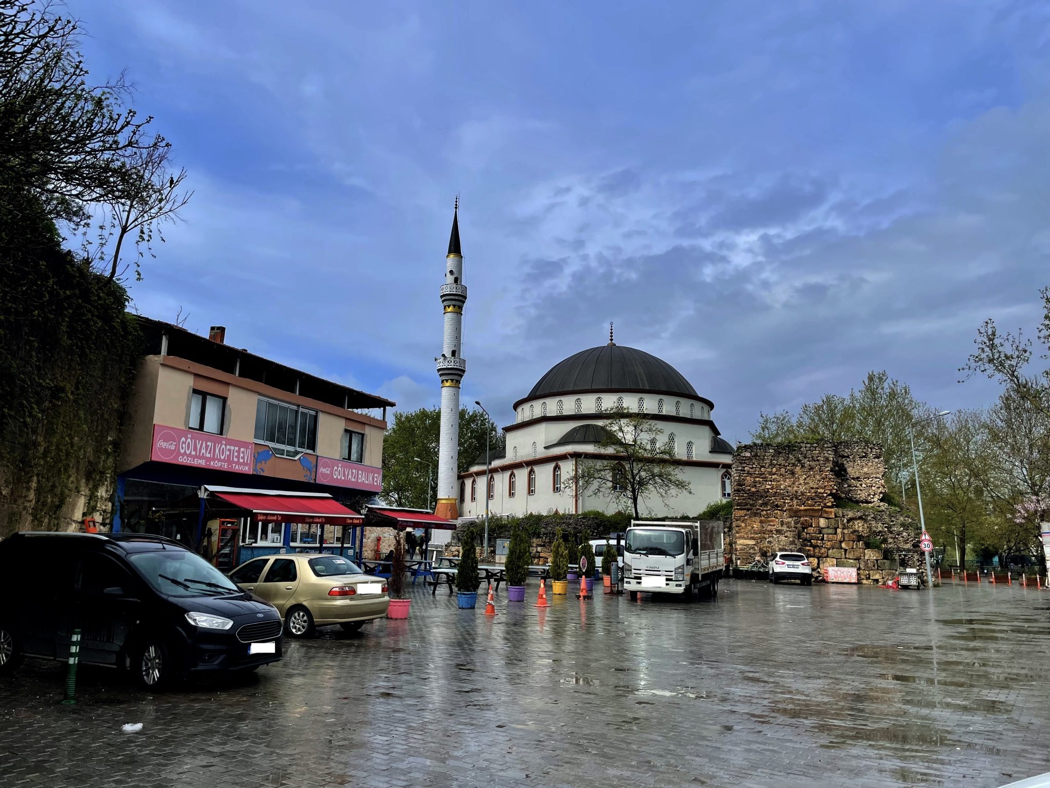 A breathtaking mosque graces the landscape in Turkey, framed by an exceptionally clear blue sky following a rainfall. Adjacent to it lie remnants of Roman architecture, a fascinating glimpse into the past.