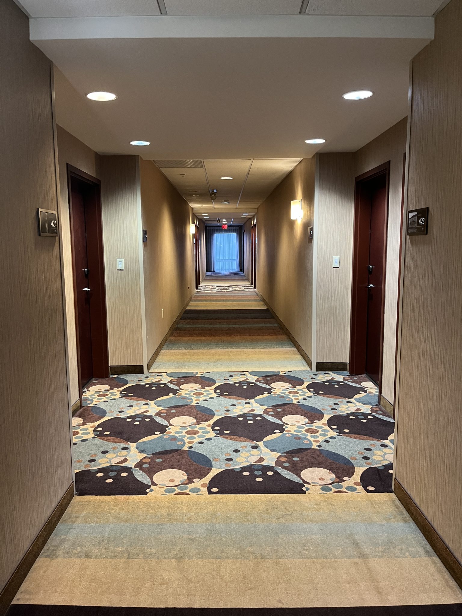 Hotel hallway, looking down the hall, maybe 8 doors long.