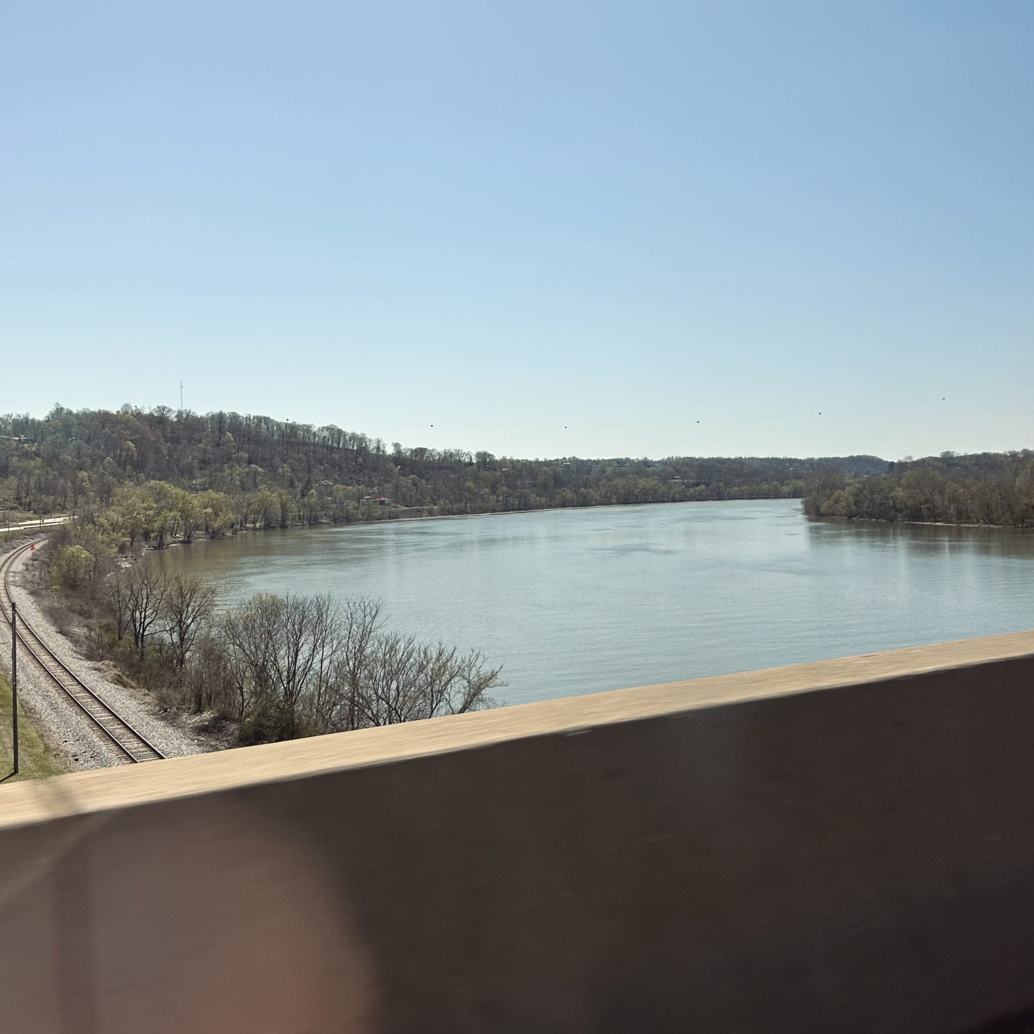 The Ohio River shot from the passenger seat of a car crossing the border from Ohio into West Virginia on a sunny day