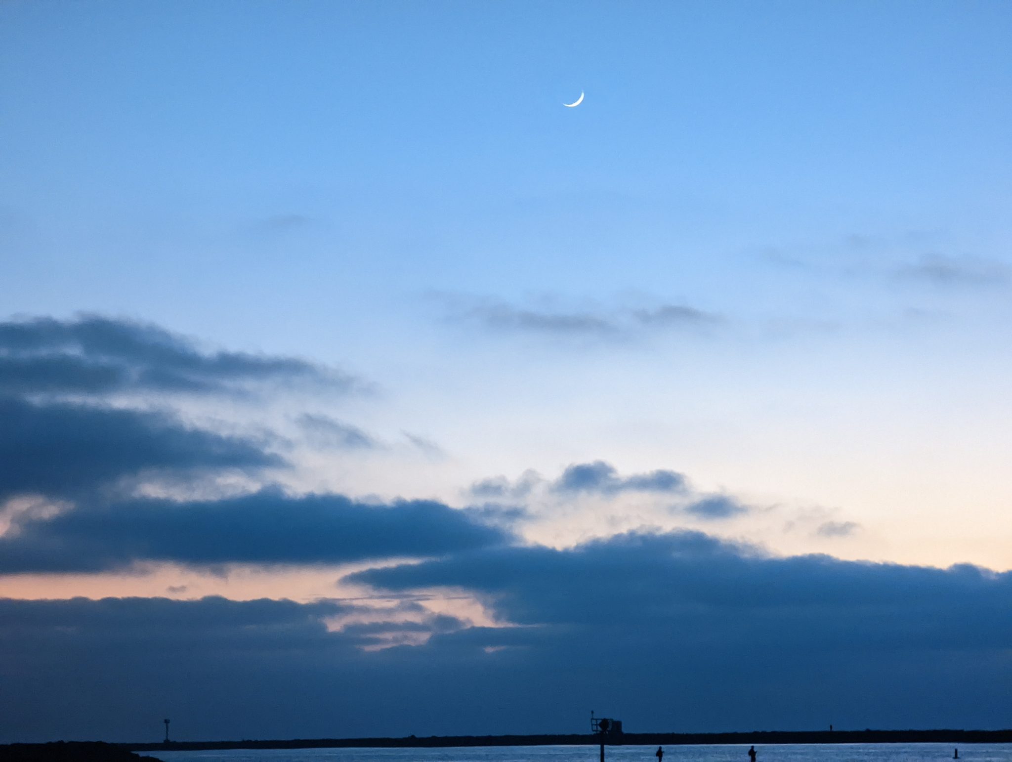 quarter moon at sunset, blue and violet tones, viewed from Dog Beach, Ocean Beach, San Diego,California.