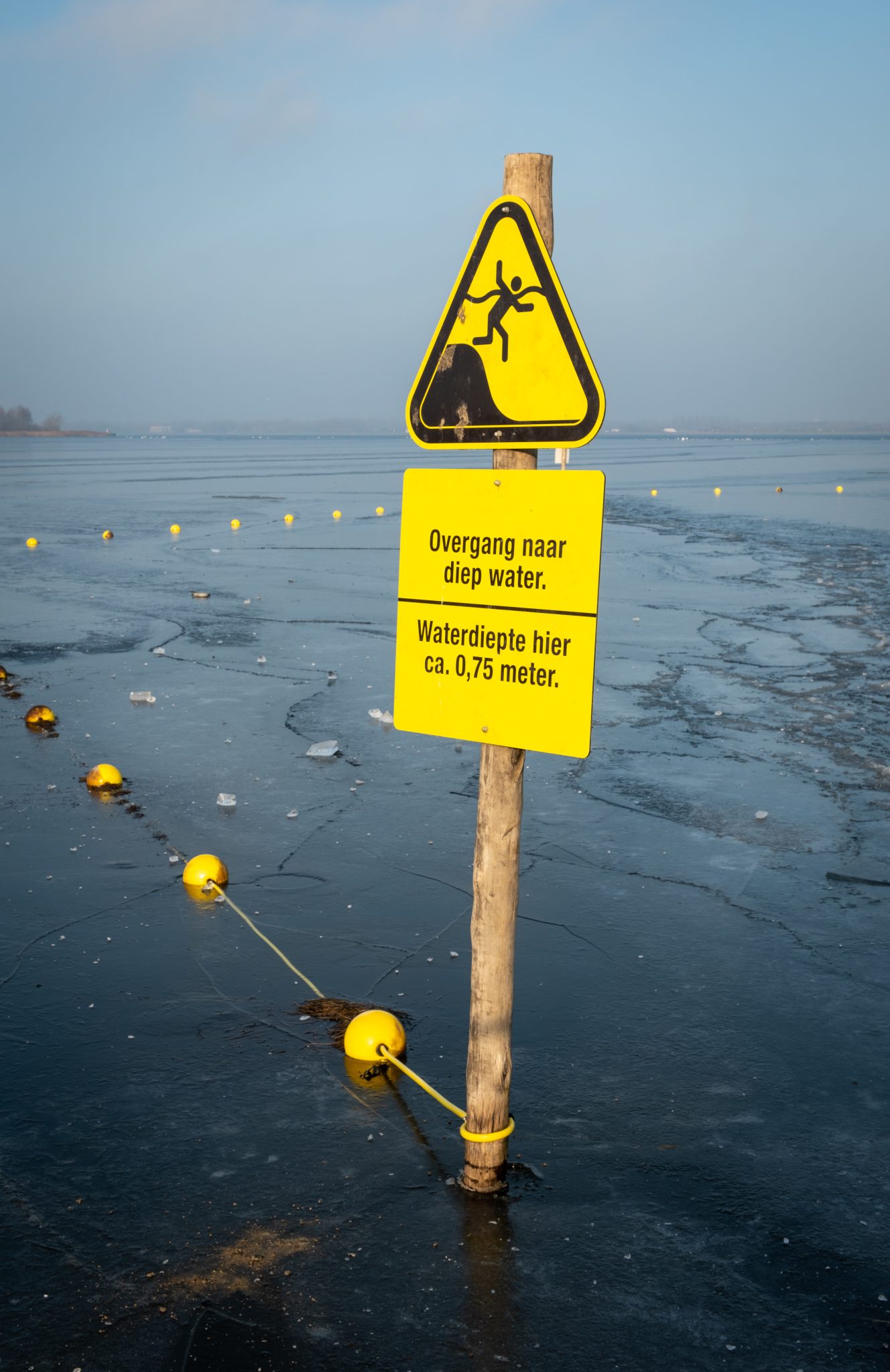 Deep water warning sign (Dutch) on a frozen lake