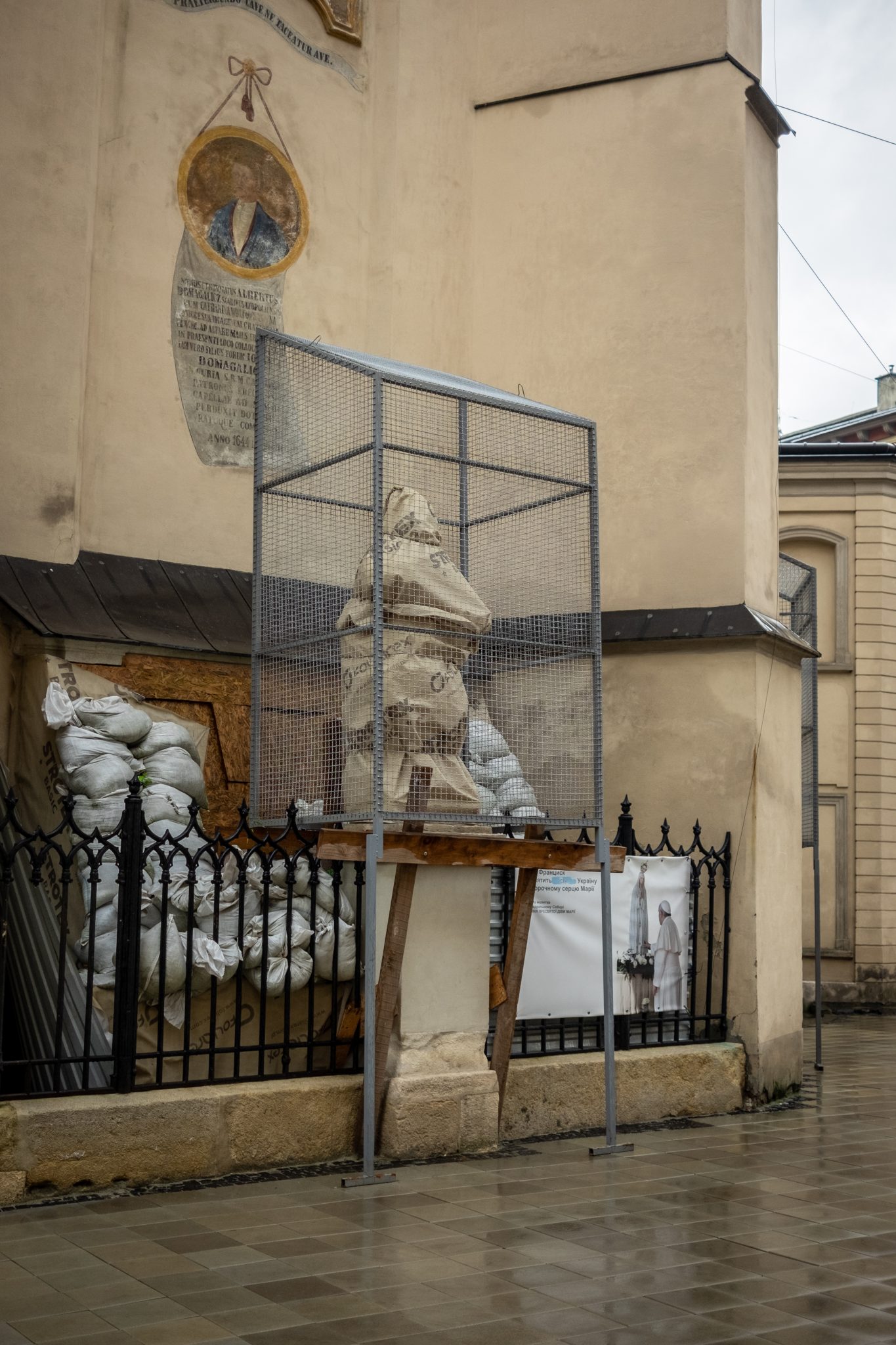 Protective cage around a church statue in wartime Lviv, Ukraine