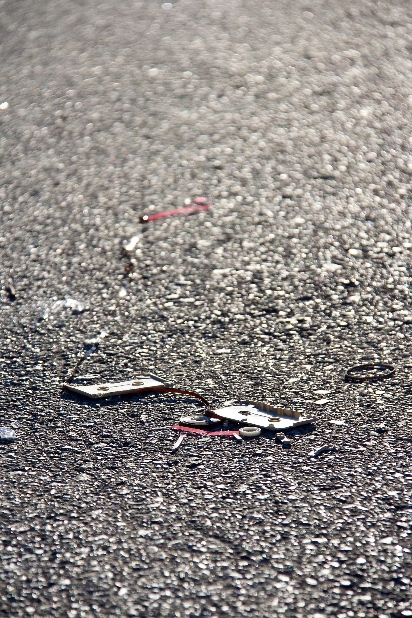 A broken cassette tape laying in the middle of the road