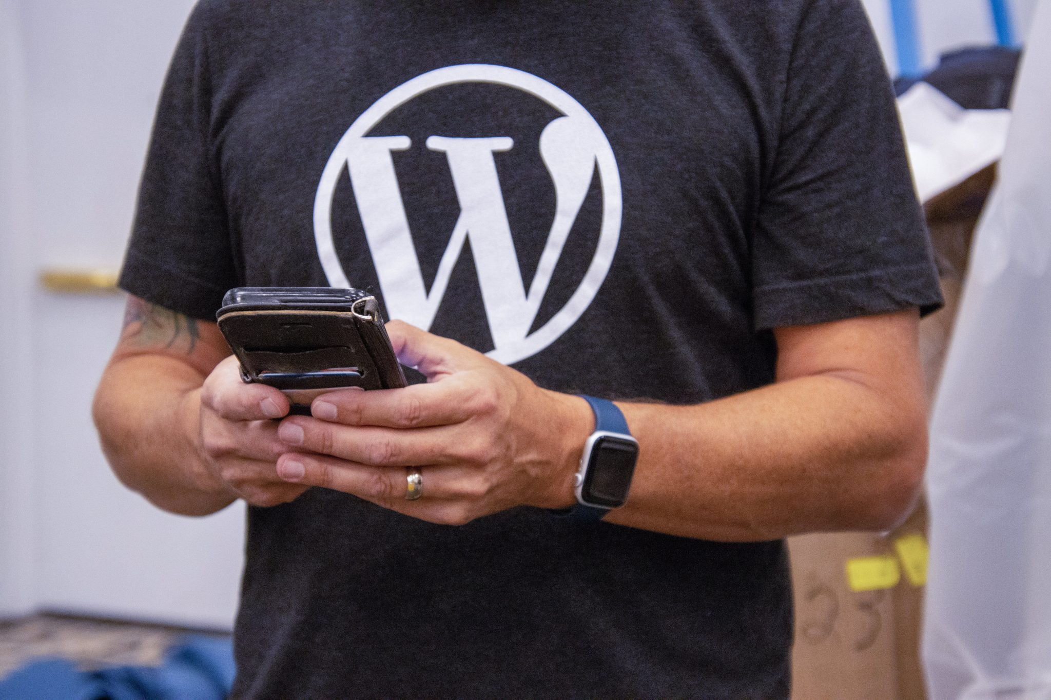 Person with WordPress shirt using a mobile device