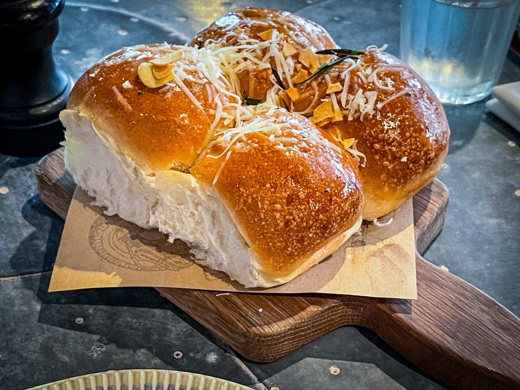 Dinner rolls at a restaurant on a wooden board