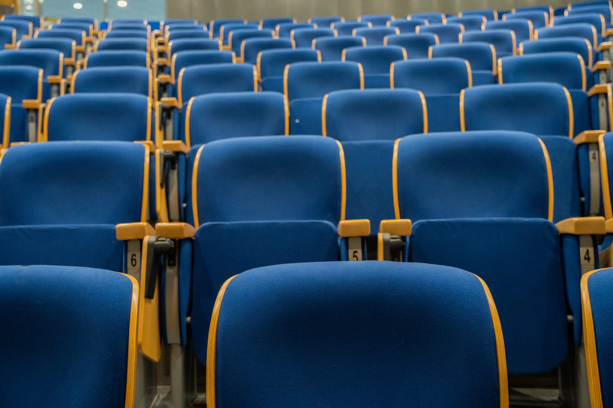 Image of a large, empty auditorium with rows of blue seats. The venue could host concerts, lectures, conferences, or movie screenings. This photo captures the anticipation of a cultural event, performance space, and public gathering. Ideal for event and v
