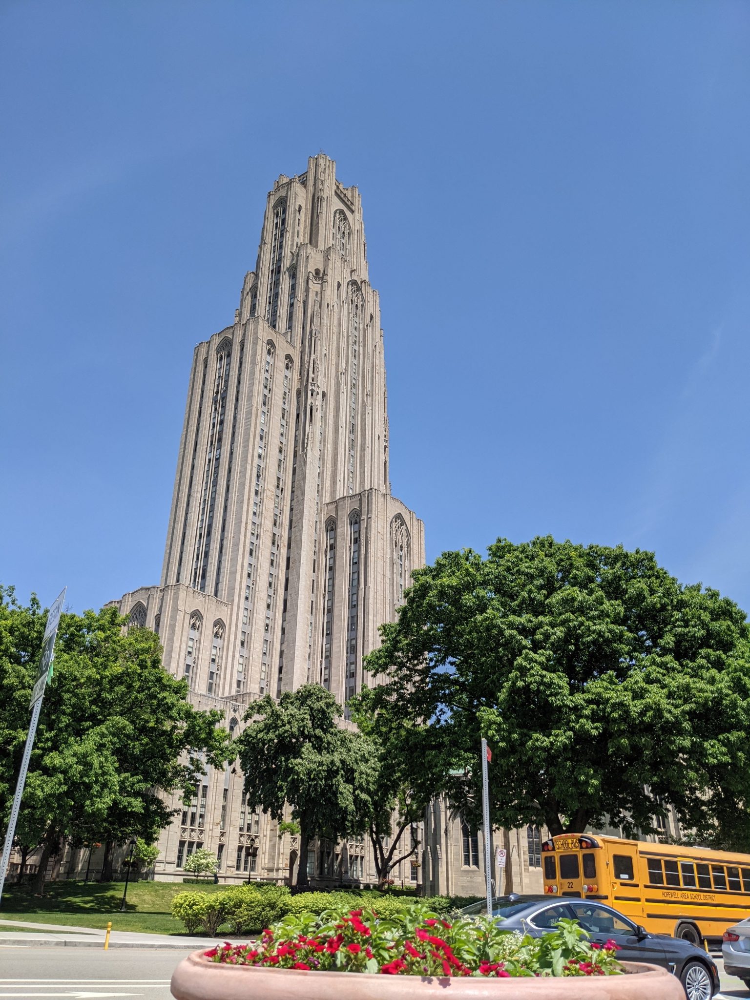 Pittsburgh's Cathedral of Learning behind some trees and in front of a blue sky