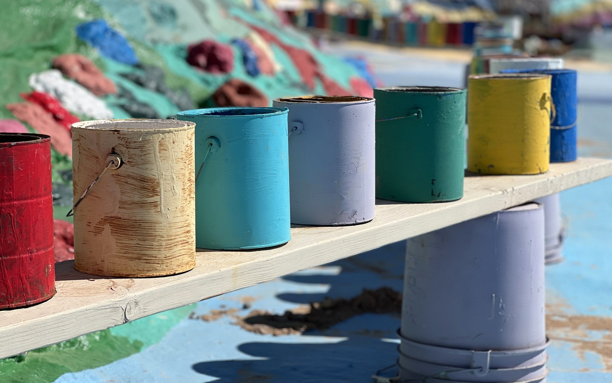 Row of bright rainbow paint cans