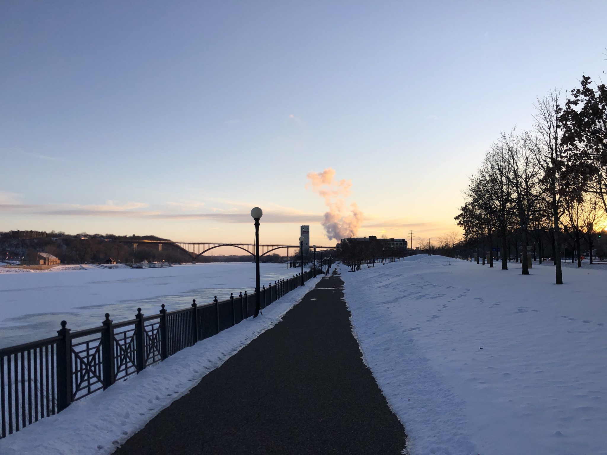 A street view of Mississippi river sunset with a bridge in background (Twin Cities)