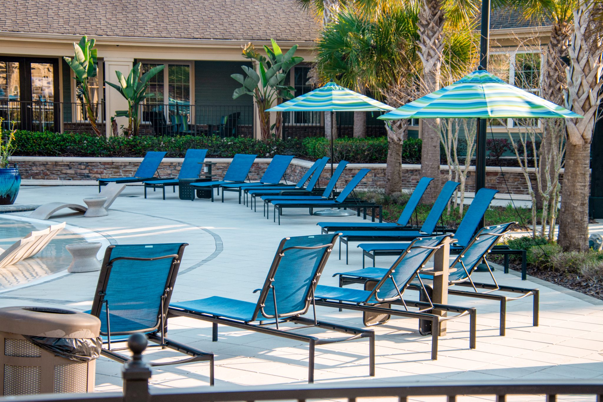 Empty lounge chairs on a resort pool deck