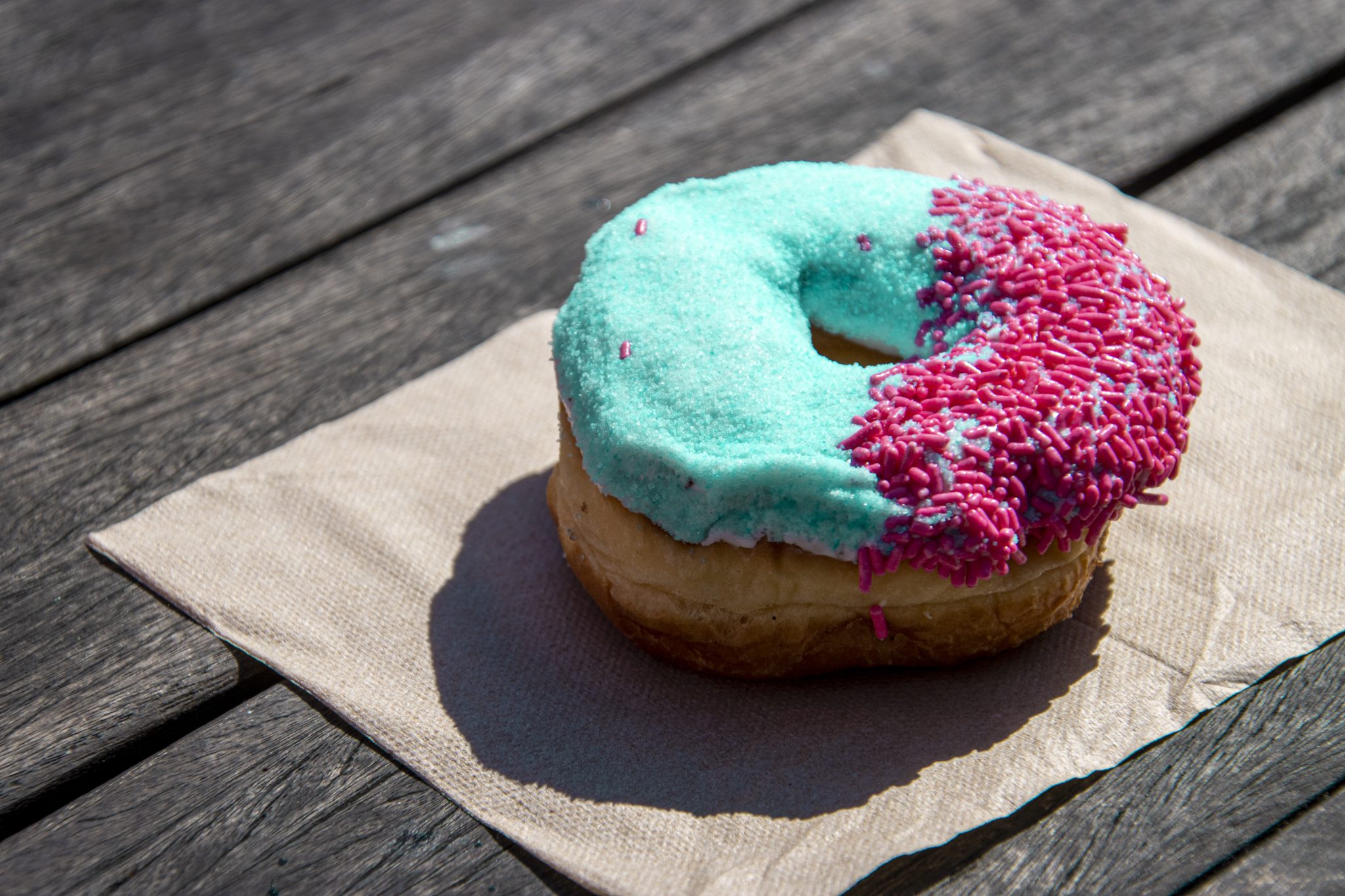 Donut with mint colored frosting and pink sprinkles