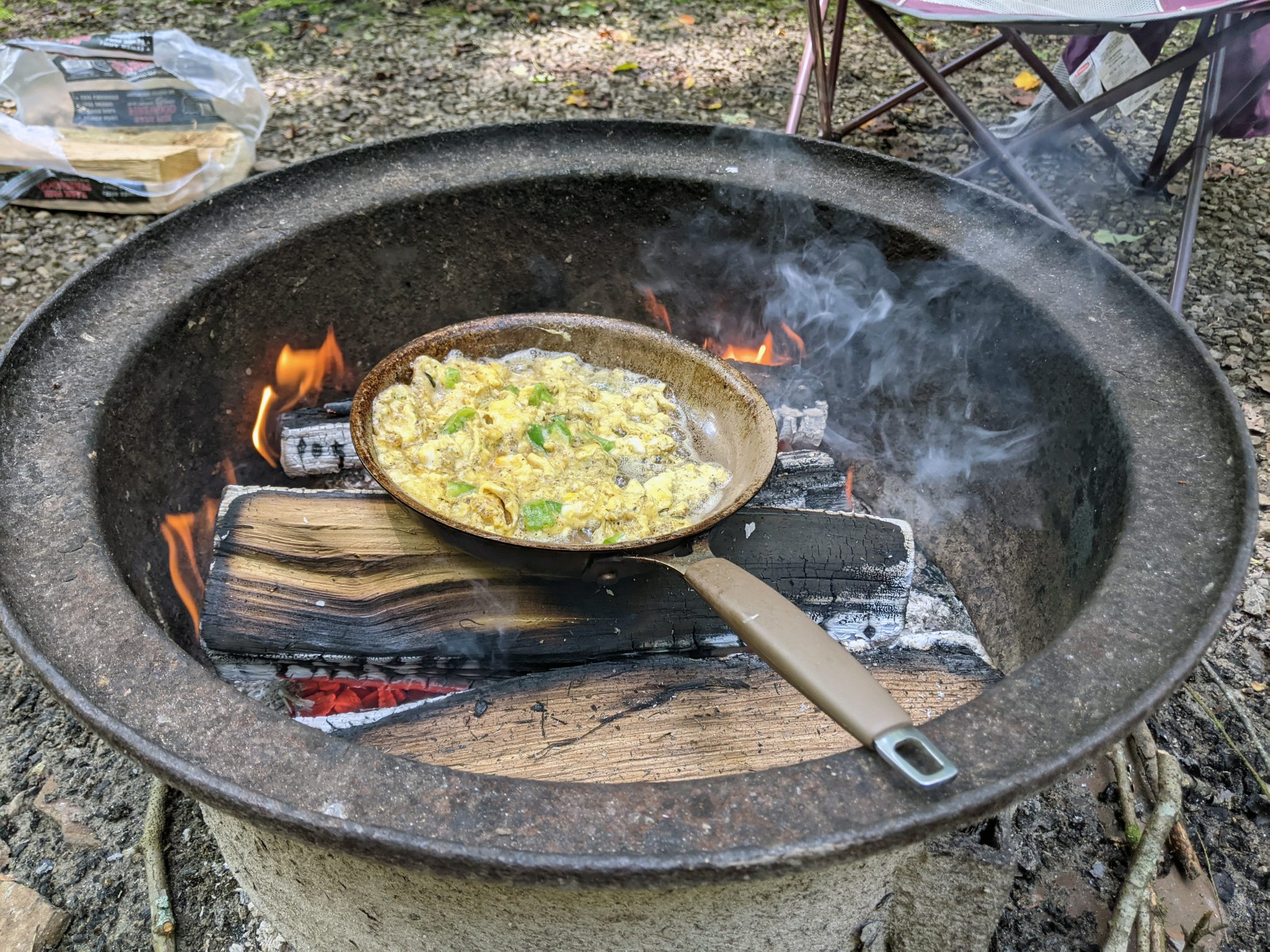 Eggs and green peppers in a pan over a fire