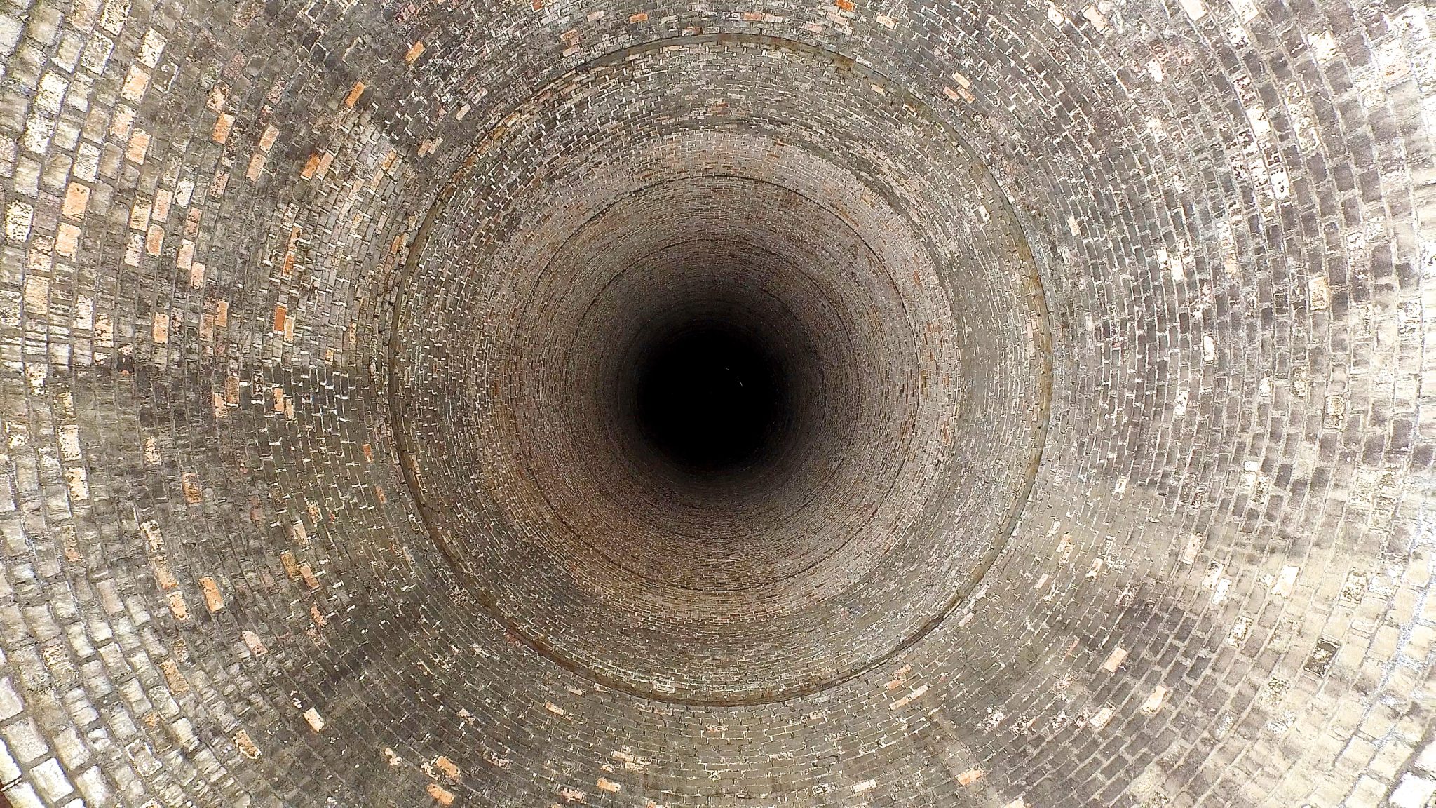 Looking down a disused power station chimney. Aerial drone footage.