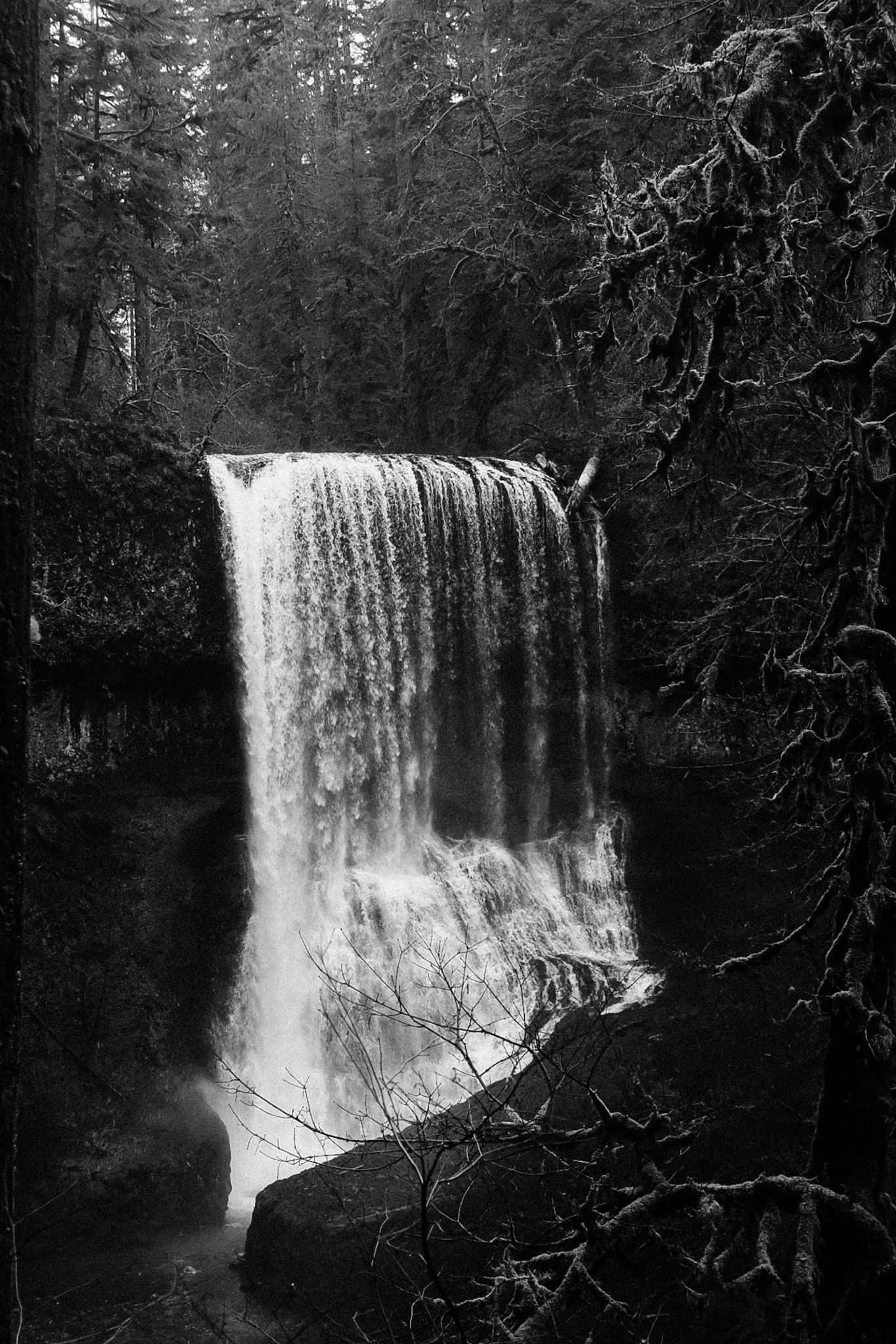 Black and white photo of a waterfall at a distance.