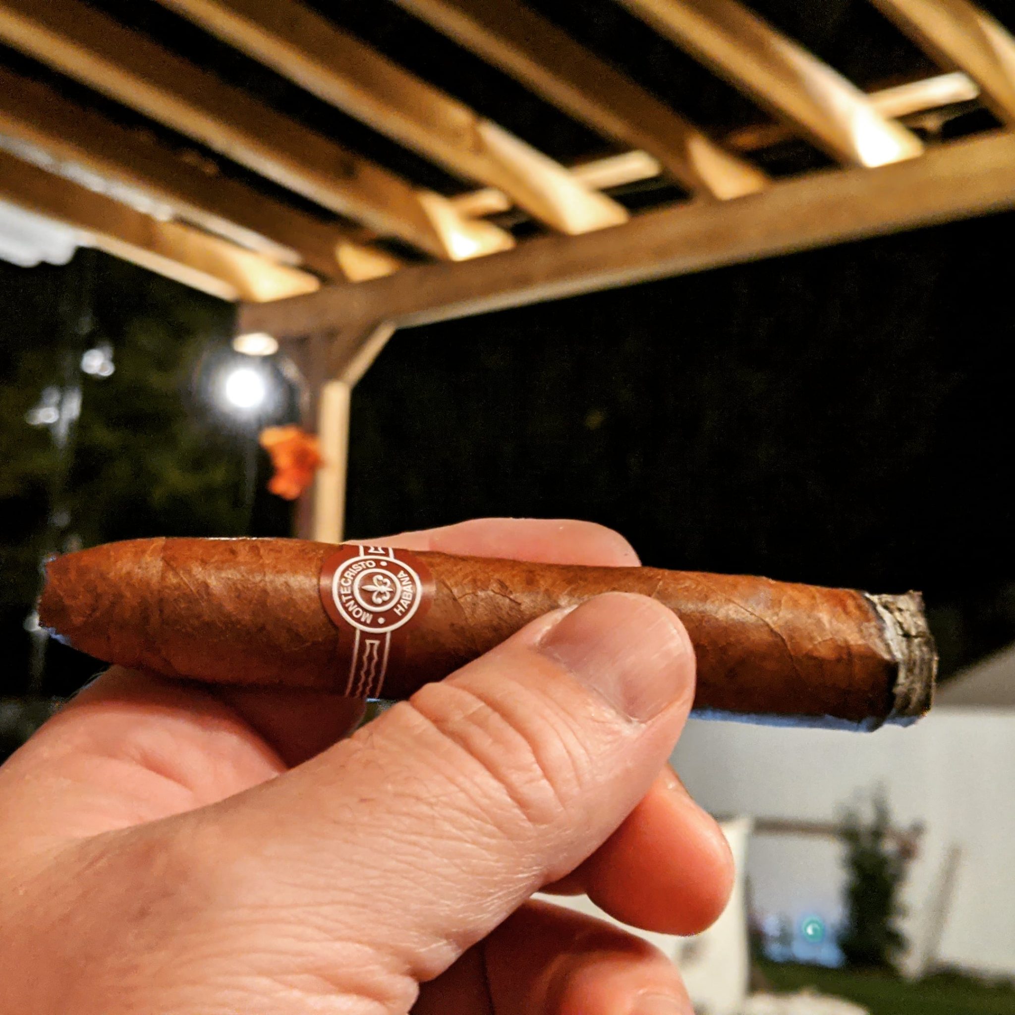 Monte Cristo cigar from Cuba, lit and in left hand