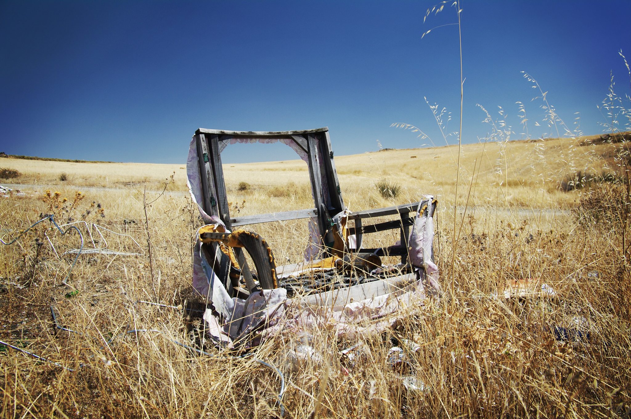 A wreck of an old armchair discarded in the Spanish countryside