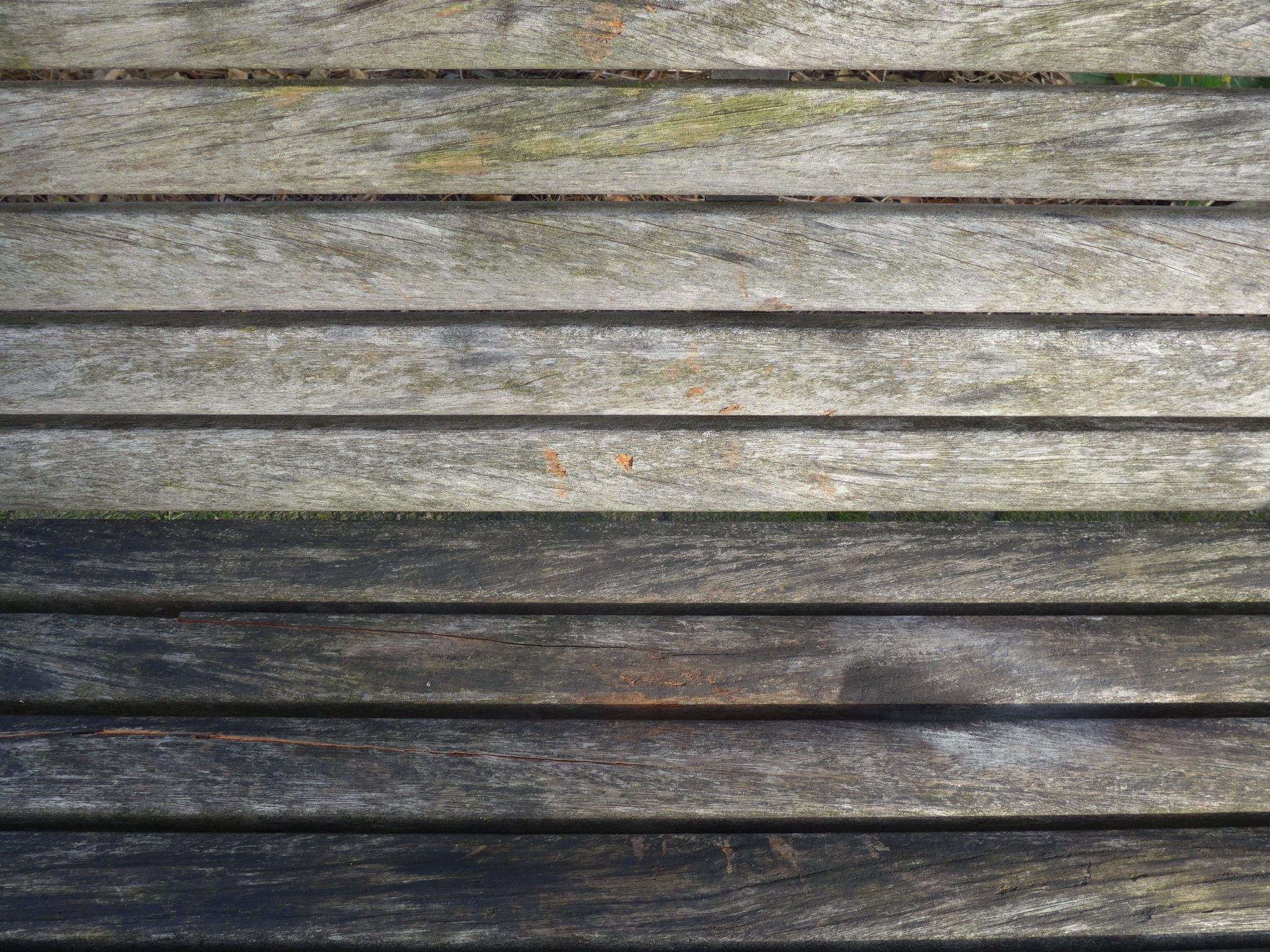 Close-up of a wooden bench with weathered planks