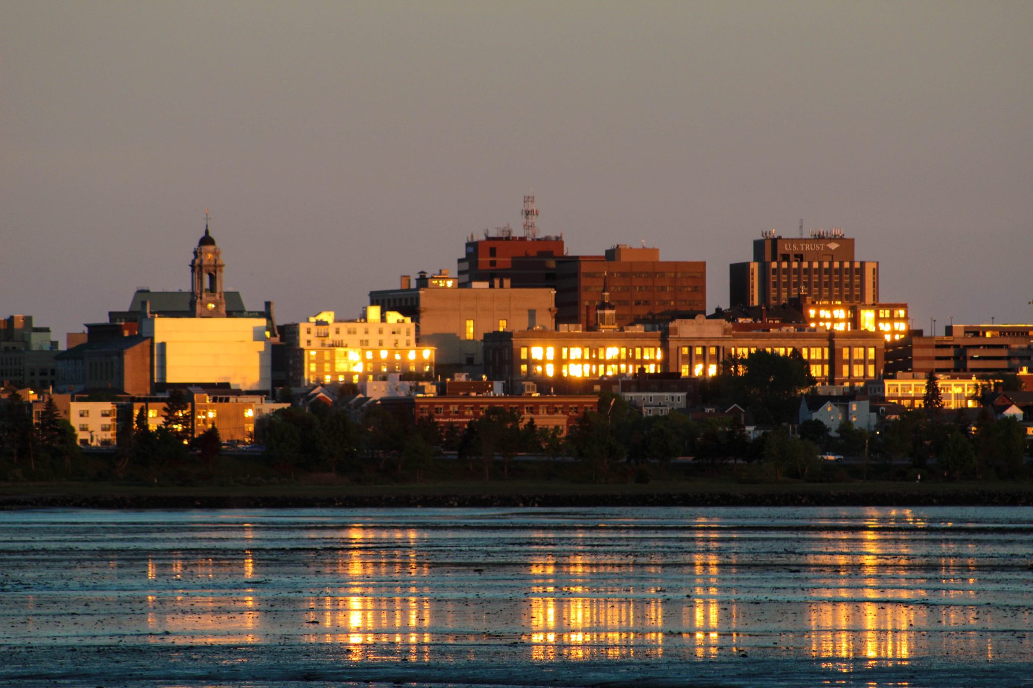 Lakeside city buildings at dusk.