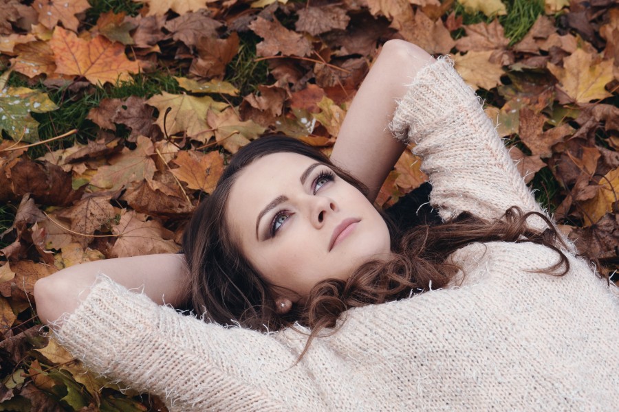 Beautiful Girl Portrait Lying on the Autumn Leaves in the Park