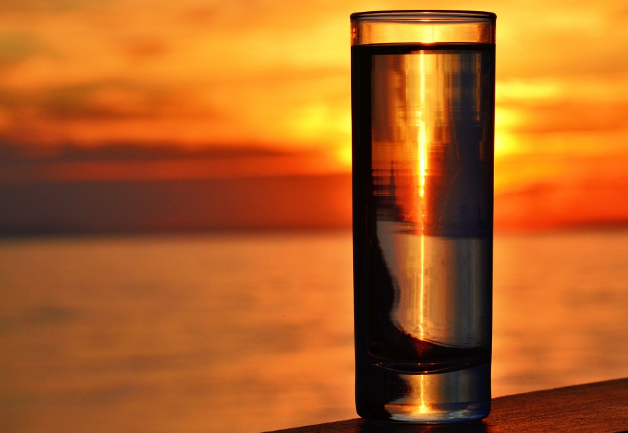 Water Glass by the Sea with Sunset Background