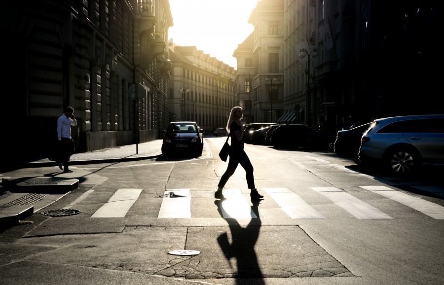 Woman walking a zebra path in the sun