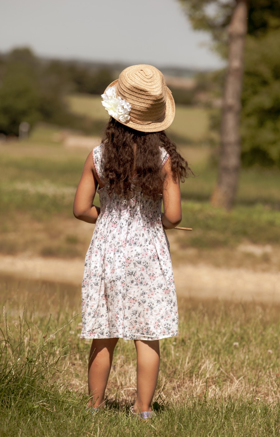 Child in hat looking over the fields 