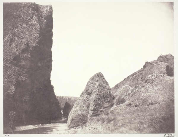 Ruisseau coulant entre une falaise et des rochers